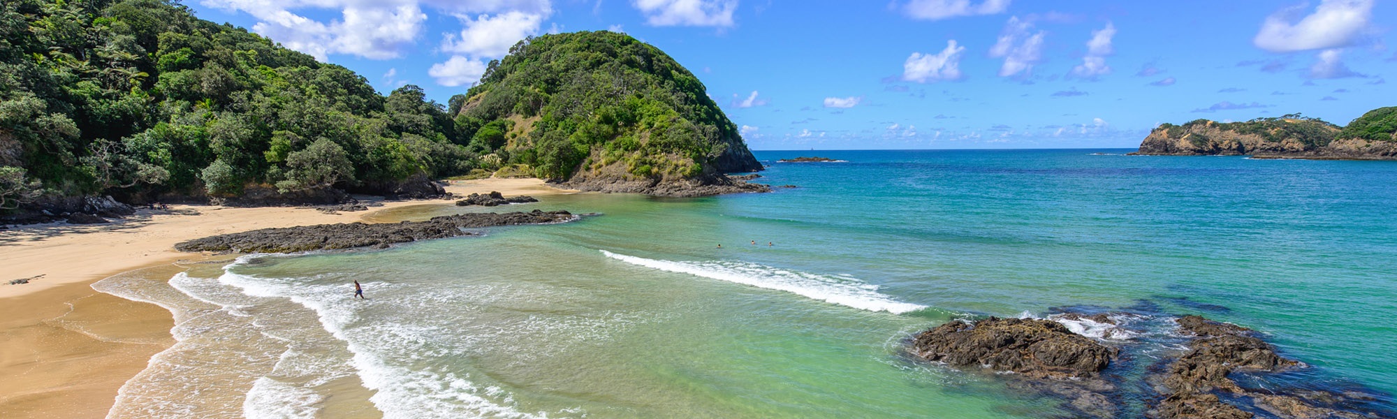 Photo of Matapōuri beach and surrounding landscape.