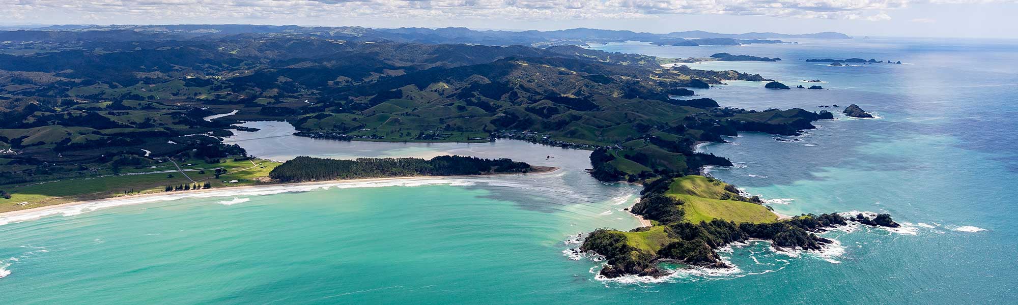Whananaki South Beach seen from above, with the footbridge in the background