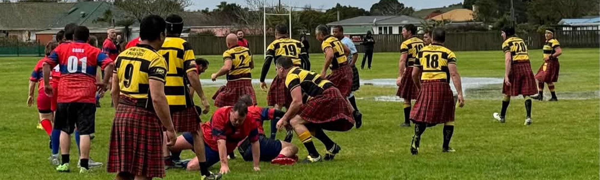 Men wearing kilts play a game of rugby